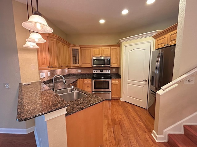 622 Seascape Way, Tampa, FL 33602 - kitchen with appliances with stainless steel finishes, a sink, a peninsula, light wood finished floors, and recessed lighting