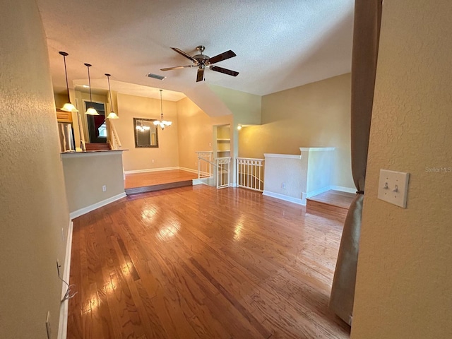622 Seascape Way, Tampa, FL 33602 - unfurnished living room with wood finished floors, ceiling fan, baseboards, a chandelier, and a textured wall