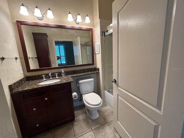622 Seascape Way, Tampa, FL 33602 - bathroom featuring toilet, a textured wall, vanity, tile patterned floors, and bath / shower combo with glass door