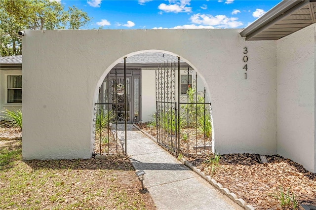 3041 Waterfall Dr, Spring Hill, FL 34608 - property entrance featuring stucco siding and a gate