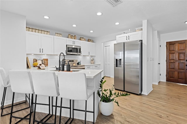 3041 Waterfall Dr, Spring Hill, FL 34608 - kitchen with stainless steel appliances, a peninsula, a kitchen breakfast bar, a sink, and light countertops
