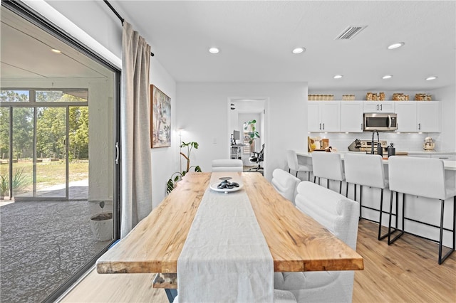 3041 Waterfall Dr, Spring Hill, FL 34608 - dining space with light wood-style flooring and recessed lighting