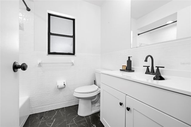 3041 Waterfall Dr, Spring Hill, FL 34608 - full bath featuring tile walls, marble look tiles, toilet, vanity, and wainscoting