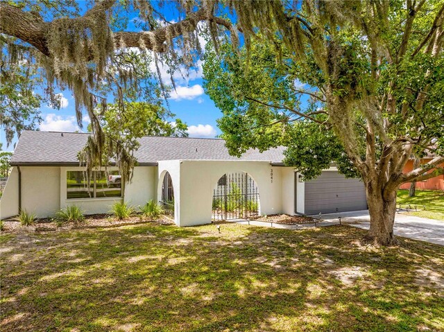 3041 Waterfall Dr, Spring Hill, FL 34608 - view of front of house featuring fence, a garage, concrete driveway, stucco siding, and roof with shingles