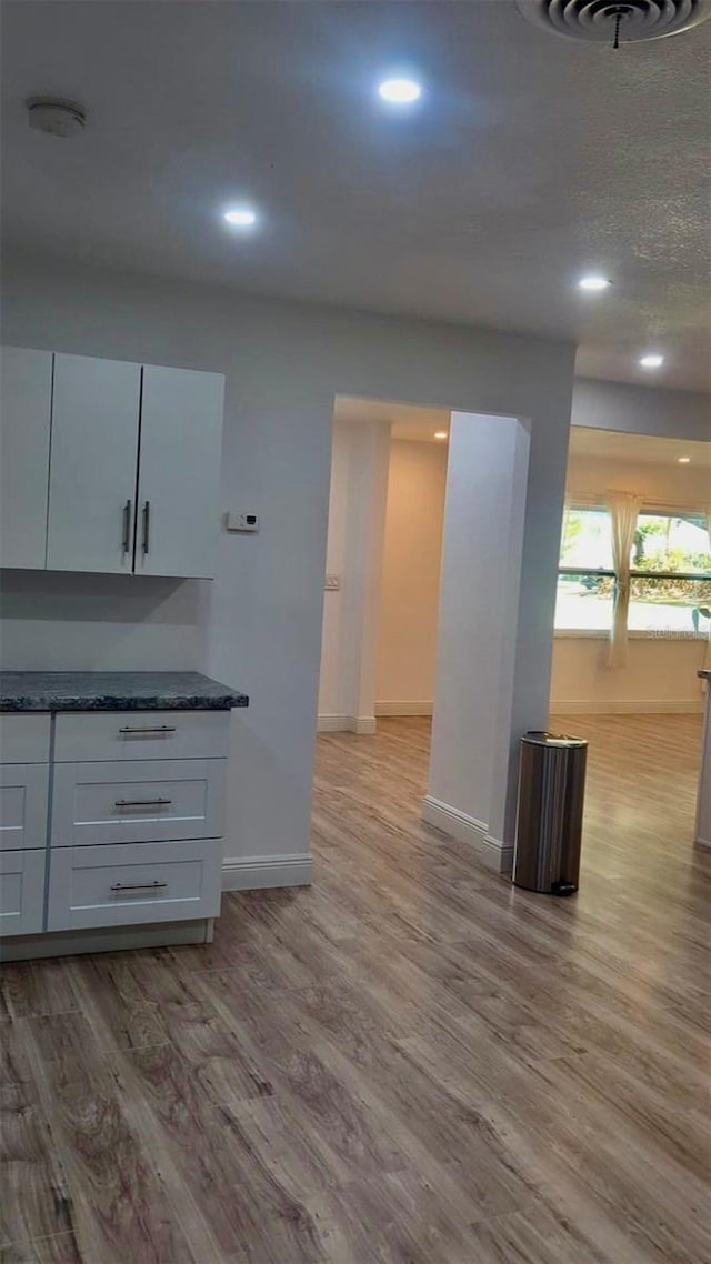 4824 Huntington St NE, Saint Petersburg, FL 33703 - kitchen with light wood-type flooring, baseboards, recessed lighting, and white cabinets
