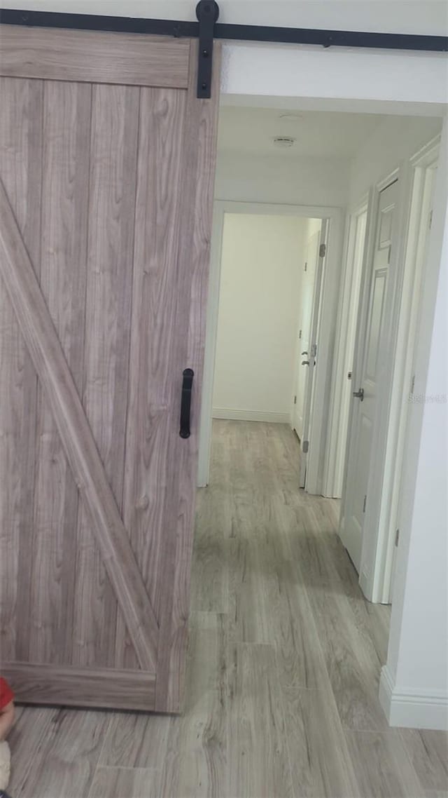 4824 Huntington St NE, Saint Petersburg, FL 33703 - hall with a barn door, baseboards, and light wood-type flooring