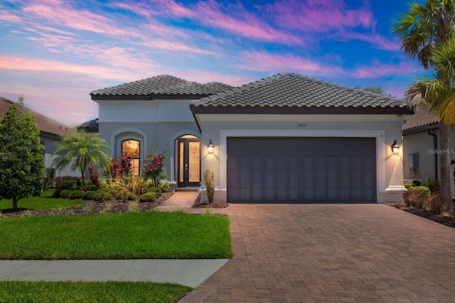 5410 Morey Farms Loop, Palmetto, FL 34221 - mediterranean / spanish-style house featuring decorative driveway, an attached garage, a tiled roof, a yard, and stucco siding