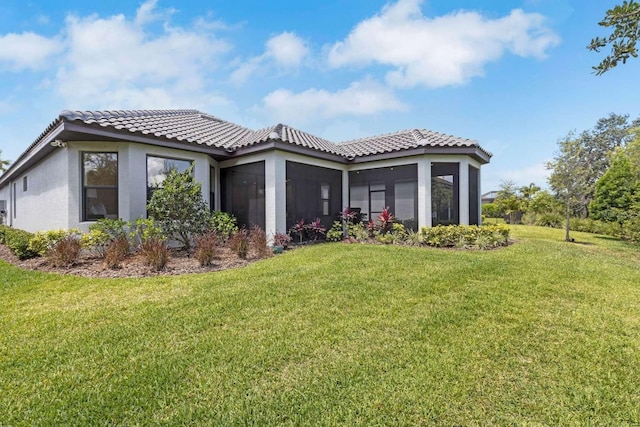 5410 Morey Farms Loop, Palmetto, FL 34221 - rear view of property featuring a yard, stucco siding, a sunroom, and a tile roof