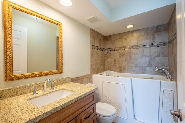 2530 Gary Cir Unit 301, Dunedin, FL 34698 - bathroom featuring tile walls, a tub to relax in, toilet, vanity, and recessed lighting