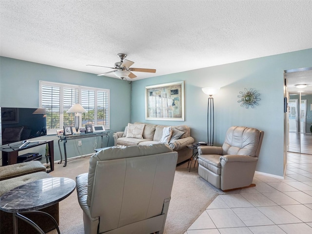 4700 Cove Cir Unit 301, Saint Petersburg, FL 33708 - living room featuring ceiling fan, a textured ceiling, light tile patterned flooring, and baseboards