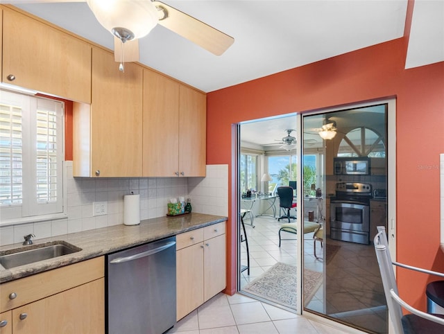 4700 Cove Cir Unit 301, Saint Petersburg, FL 33708 - kitchen featuring appliances with stainless steel finishes, ceiling fan, light brown cabinetry, and tasteful backsplash