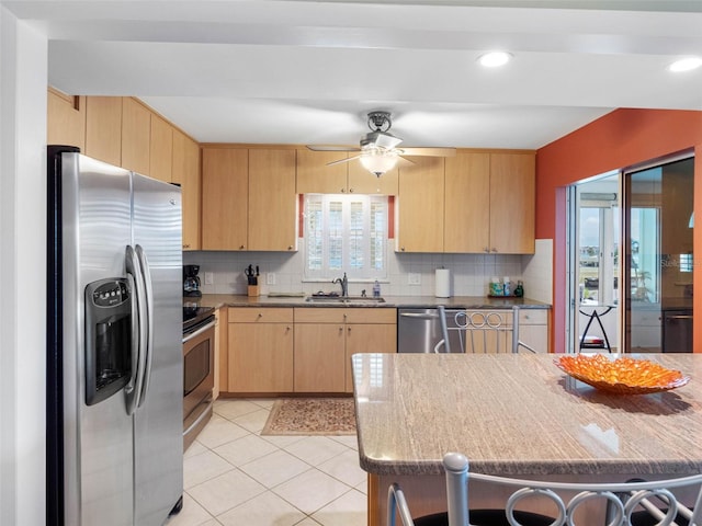 4700 Cove Cir Unit 301, Saint Petersburg, FL 33708 - kitchen featuring stainless steel appliances, light brown cabinets, a sink, tasteful backsplash, and recessed lighting