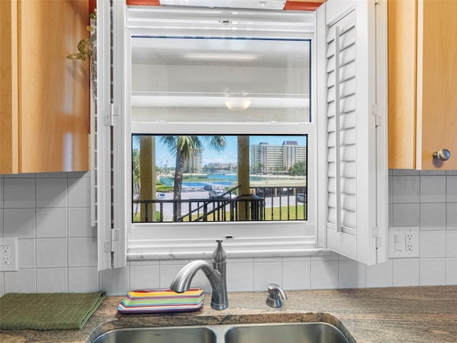 4700 Cove Cir Unit 301, Saint Petersburg, FL 33708 - kitchen view of backsplash, a sink, and dark stone countertops