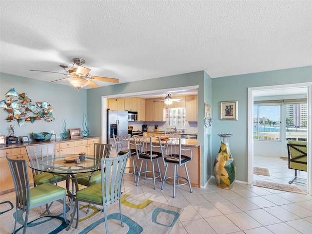 4700 Cove Cir Unit 301, Saint Petersburg, FL 33708 - dining area featuring healthy amount of natural light, a ceiling fan, a textured ceiling, and light tile patterned floors