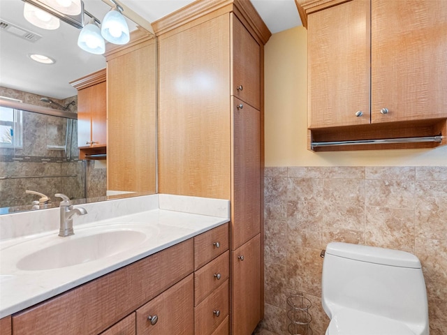 4700 Cove Cir Unit 301, Saint Petersburg, FL 33708 - bathroom with vanity, toilet, tile walls, and wainscoting