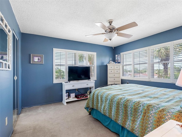 4700 Cove Cir Unit 301, Saint Petersburg, FL 33708 - bedroom with multiple windows, carpet flooring, a textured ceiling, ceiling fan, and baseboards