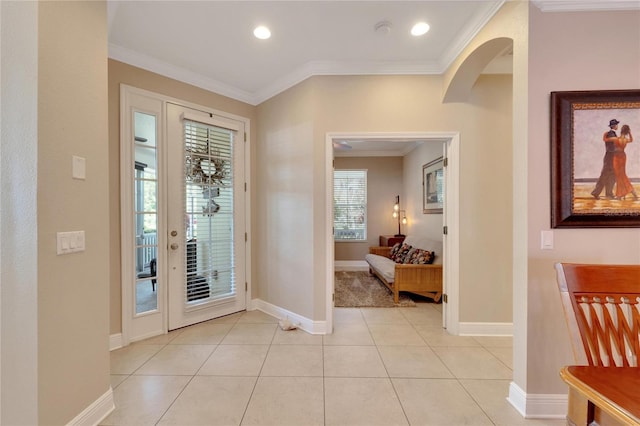 entryway featuring baseboards, ornamental molding, recessed lighting, light tile patterned flooring, and arched walkways