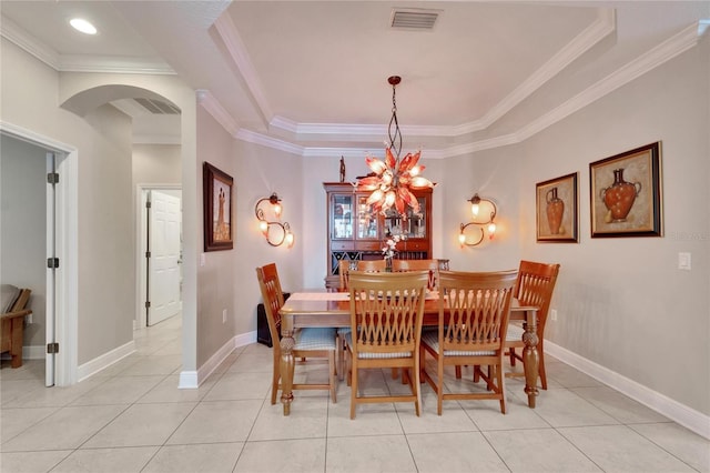 dining area featuring arched walkways, crown molding, light tile patterned floors, and baseboards