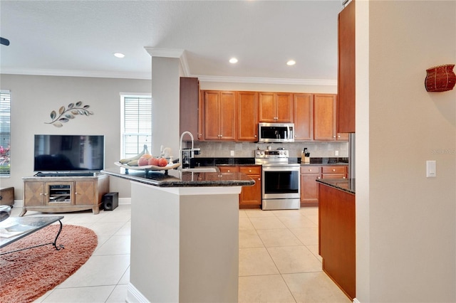 kitchen with appliances with stainless steel finishes, a sink, a peninsula, backsplash, and ornamental molding