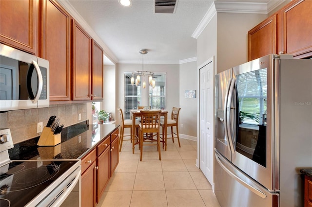kitchen featuring appliances with stainless steel finishes, a chandelier, tasteful backsplash, brown cabinetry, and crown molding