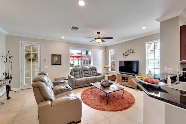 living room featuring crown molding, healthy amount of natural light, light tile patterned floors, ceiling fan, and recessed lighting