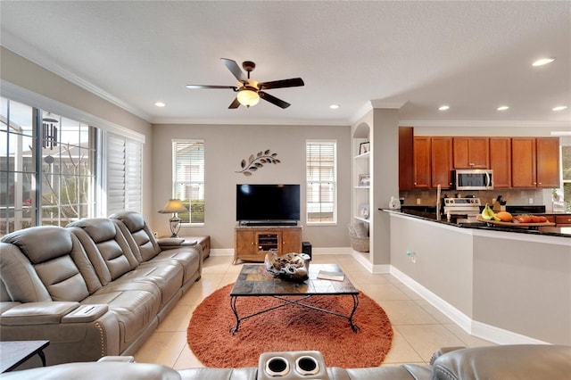 living room with light tile patterned flooring, a ceiling fan, recessed lighting, ornamental molding, and baseboards