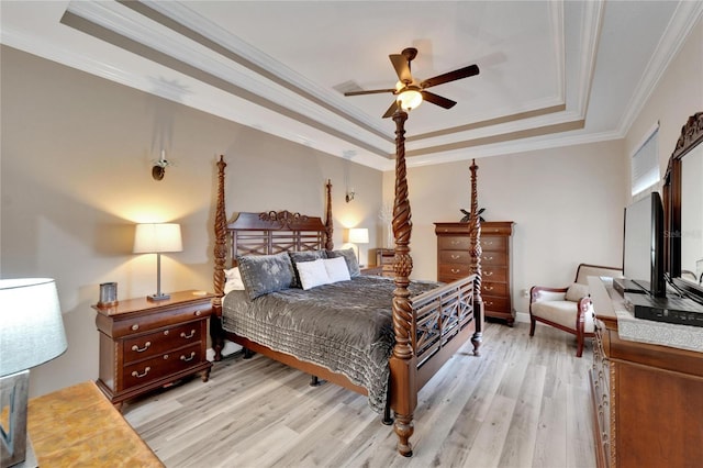 bedroom with a raised ceiling, light wood-type flooring, crown molding, and ceiling fan