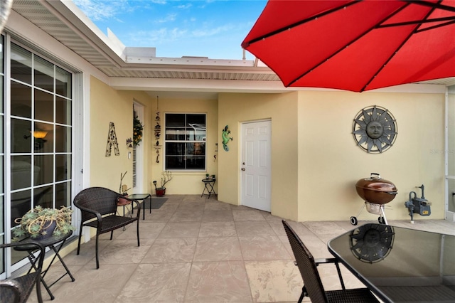 doorway to property featuring stucco siding and a patio