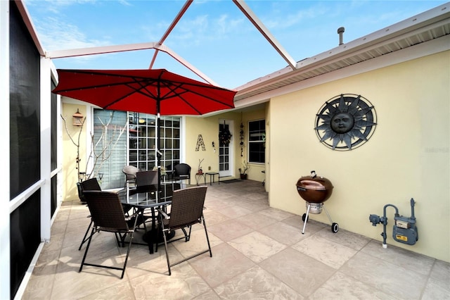 view of patio / terrace featuring outdoor dining space and glass enclosure