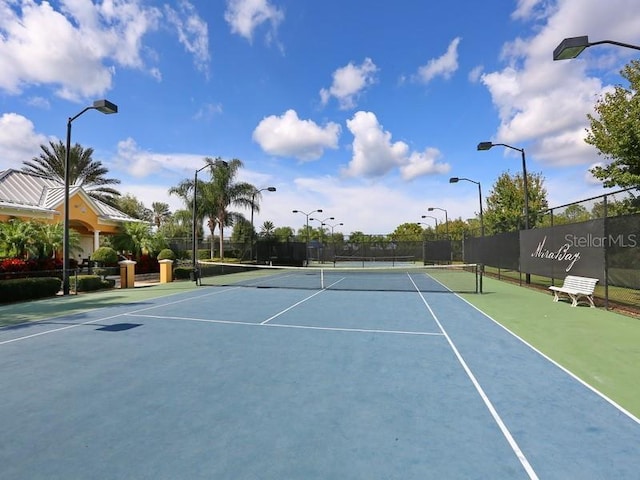 view of tennis court featuring fence and community basketball court