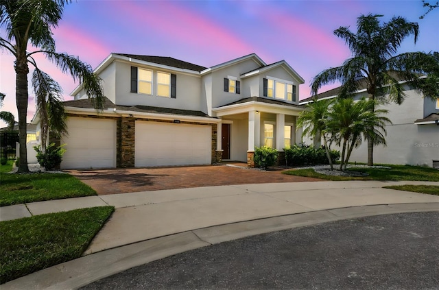 4950 Chase Ct, Saint Cloud, FL 34772 - view of front facade with stucco siding, an attached garage, decorative driveway, and stone siding