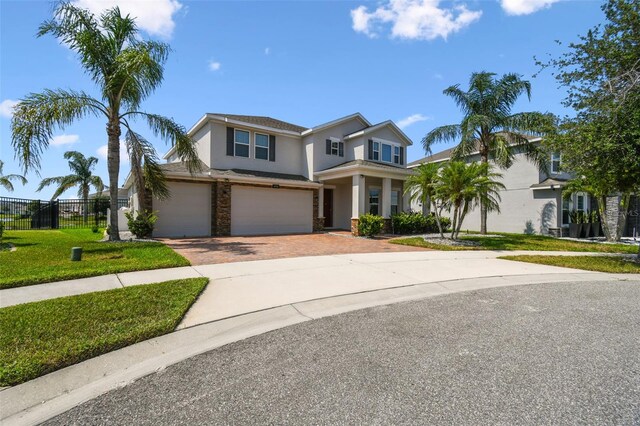 4950 Chase Ct, Saint Cloud, FL 34772 - view of front facade featuring stucco siding, decorative driveway, an attached garage, and stone siding