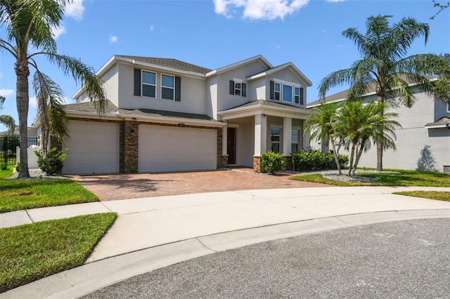 4950 Chase Ct, Saint Cloud, FL 34772 - view of front of home with stucco siding, decorative driveway, a garage, and stone siding