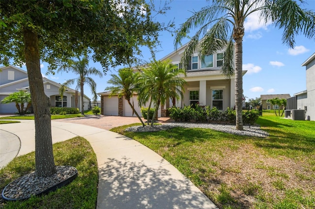 4950 Chase Ct, Saint Cloud, FL 34772 - view of front of property with decorative driveway, a front yard, central AC unit, and stucco siding