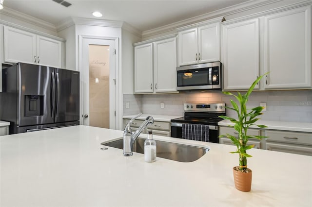 4950 Chase Ct, Saint Cloud, FL 34772 - kitchen with stainless steel appliances, a sink, crown molding, light countertops, and decorative backsplash