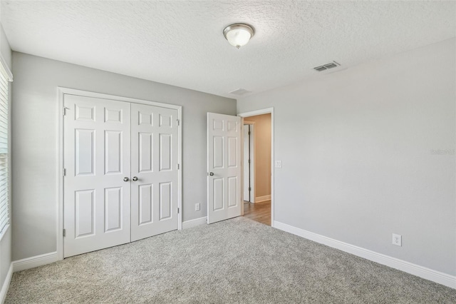 4950 Chase Ct, Saint Cloud, FL 34772 - unfurnished bedroom featuring carpet, a closet, baseboards, and a textured ceiling