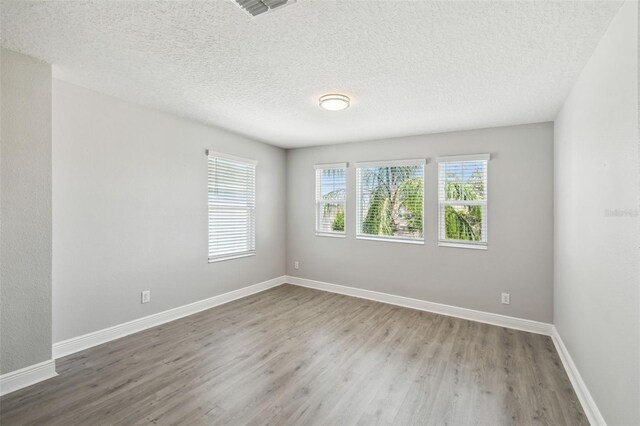 4950 Chase Ct, Saint Cloud, FL 34772 - empty room with wood finished floors, baseboards, and a textured ceiling