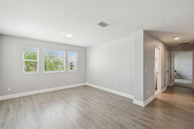 4950 Chase Ct, Saint Cloud, FL 34772 - spare room featuring wood finished floors, baseboards, and a textured ceiling