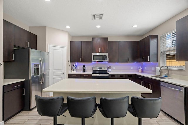 1520 W Fig St, Tampa, FL 33606 - kitchen featuring appliances with stainless steel finishes, a sink, a breakfast bar, light countertops, and recessed lighting