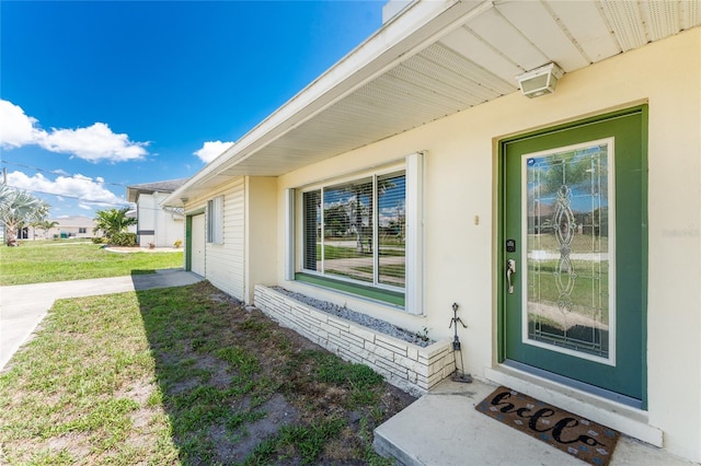 3420 Santa Clara Dr, Punta Gorda, FL 33983 - property entrance with a yard and stucco siding
