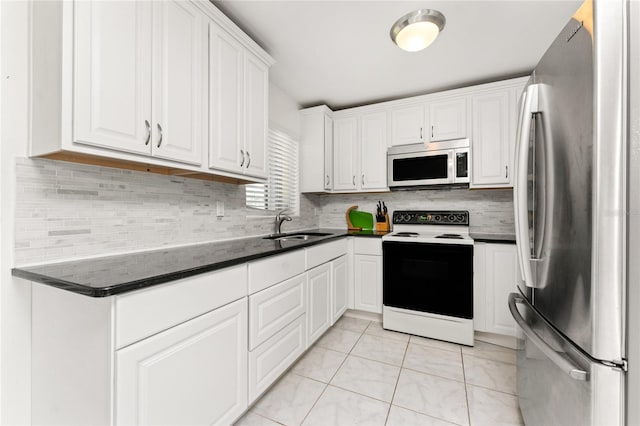 3420 Santa Clara Dr, Punta Gorda, FL 33983 - kitchen with appliances with stainless steel finishes, dark countertops, a sink, white cabinetry, and tasteful backsplash