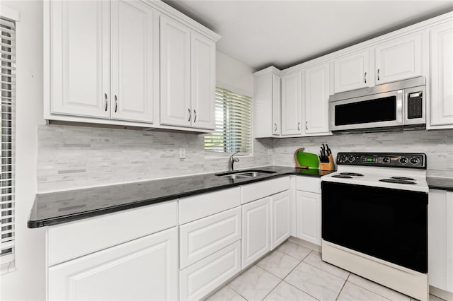 3420 Santa Clara Dr, Punta Gorda, FL 33983 - kitchen featuring stainless steel microwave, electric range oven, a sink, white cabinets, and backsplash