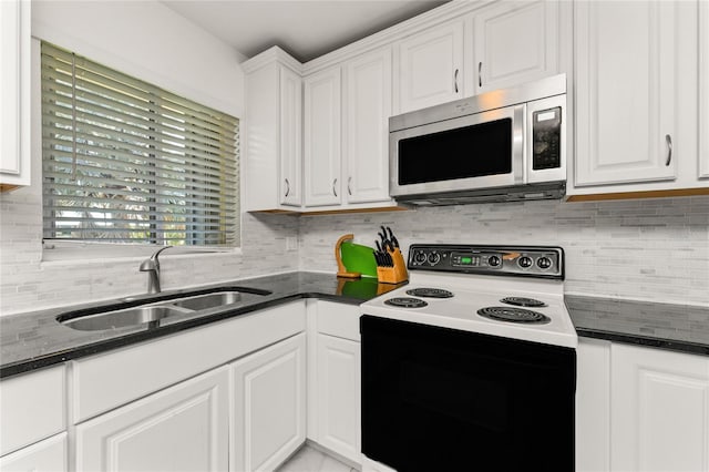 3420 Santa Clara Dr, Punta Gorda, FL 33983 - kitchen featuring stainless steel microwave, range with electric cooktop, a sink, white cabinetry, and decorative backsplash