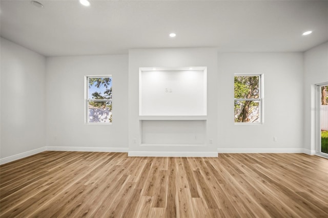 empty room with light wood-style floors, recessed lighting, and baseboards