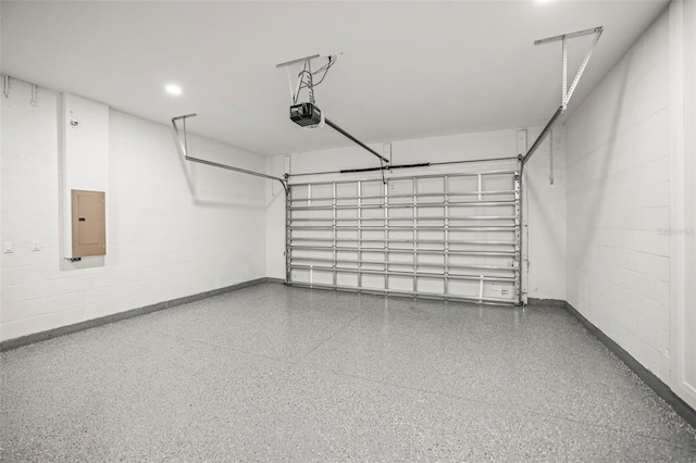 garage featuring electric panel, a garage door opener, concrete block wall, and baseboards