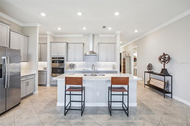 31510 Cabana Rye Ave, San Antonio, FL 33576 - kitchen with appliances with stainless steel finishes, wall chimney exhaust hood, gray cabinetry, an island with sink, and backsplash