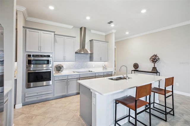 31510 Cabana Rye Ave, San Antonio, FL 33576 - kitchen with wall chimney range hood, gray cabinetry, black electric stovetop, double oven, and a breakfast bar area
