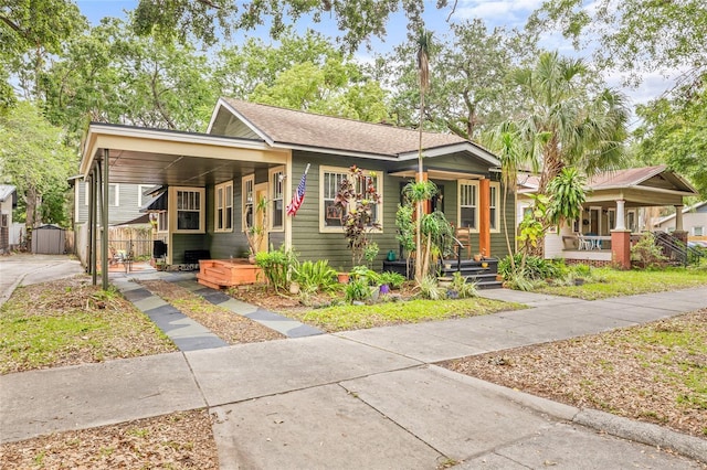 916 E Broad St, Tampa, FL 33604 - view of front facade featuring a porch, an attached carport, concrete driveway, fence, and a shingled roof