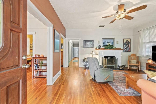 916 E Broad St, Tampa, FL 33604 - living room with light wood-style flooring, a fireplace, a ceiling fan, and baseboards