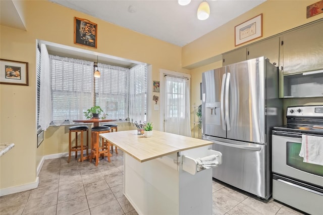 916 E Broad St, Tampa, FL 33604 - kitchen with appliances with stainless steel finishes, light tile patterned floors, baseboards, and a center island